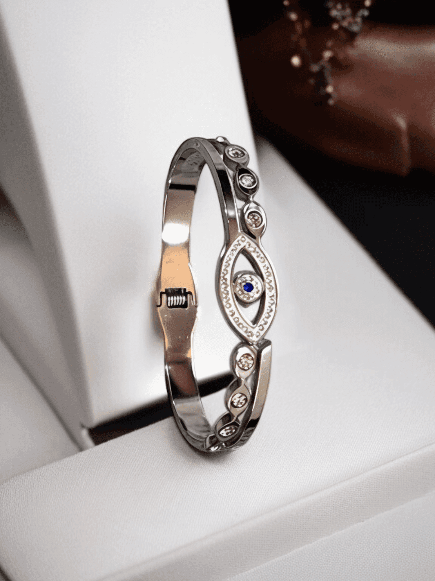 Polished Silver Tone Evil Eye Bangle Bracelet with Royal Blue Center.